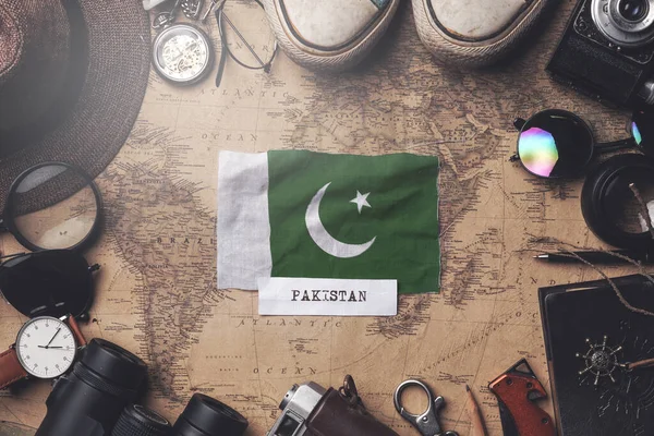 Pákistánská vlajka mezi cestovatelskými doplňky na staré mapě. — Stock fotografie
