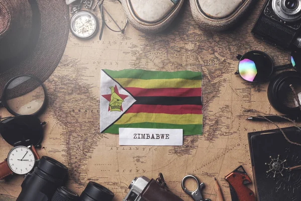 Zimbabwe Bandiera tra gli accessori del viaggiatore sulla vecchia mappa Vintage . — Foto Stock