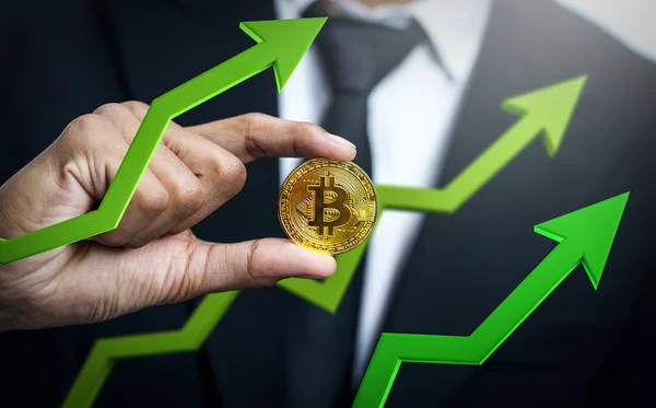 İşadamı Bitcoin 'i Yeşil 3D okla tutuyor. Bitcoin fiyatı artıyor