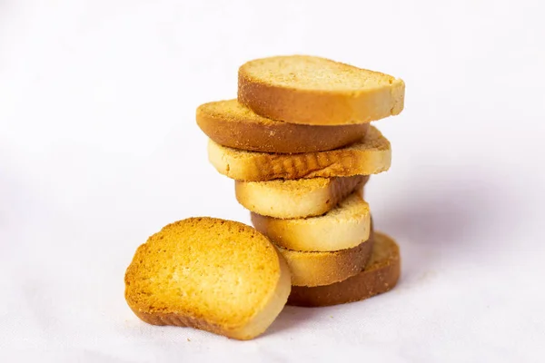 Beyaz ekmek krakerleri, üst üste istiflenmiş, kırıntılar etrafa saçılmış, beyaz arka plan. Sağlıklı yaşam için gevrek rusk ya da tost. Diyet yemek. Hint kahvaltısı ya da çayla atıştırmalık