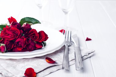 Festival tablo ayarını bej gül, şarap gözlük, peçete ve çatal bıçak takımı,