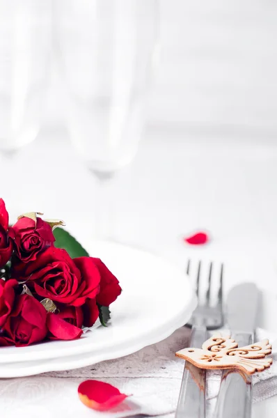Cenário festivo com rosas bege, copos de vinho, guardanapos e talheres , — Fotografia de Stock