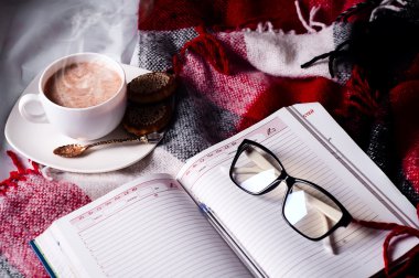 Açık kitap üzerinde kalan kakao fincan