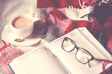 Açık kitap üzerinde kalan kakao fincan