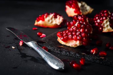 Nar ve nar taneleri karanlık bir arka plan üzerinde