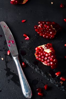 Nar ve nar taneleri karanlık bir arka plan üzerinde