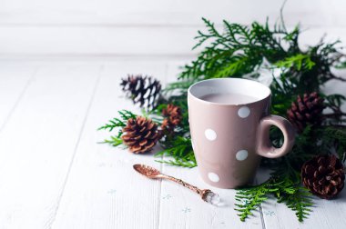 Vintage ahşap arka plan üzerinde sıcak kakao fincan Ladin ve çam kozalakları ile dekore edilmiştir.,