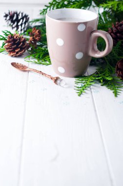 Vintage ahşap arka plan üzerinde sıcak kakao fincan Ladin ve çam kozalakları ile dekore edilmiştir.,