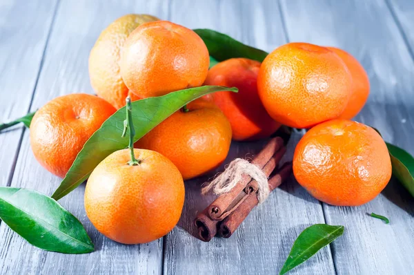 Tangeriner med blad på träbord. — Stockfoto