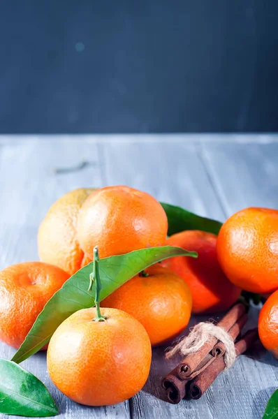 Tangeriner med blad på träbord. — Stockfoto