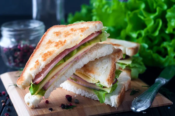 Club sandwich med en sallad på en träplatta — Stockfoto