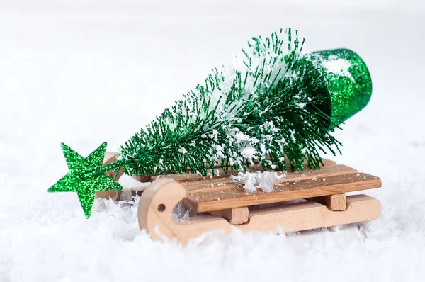 Wooden winter sleigh carrying a small Christmas tree — Stock Photo, Image