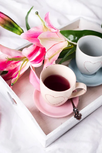 Bandeja con taza de té caliente en la cama , — Foto de Stock