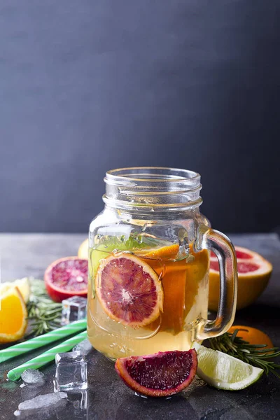 Jar of lemonade with citrus fruits — Stock Photo, Image