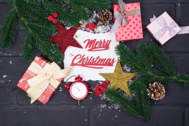 Çerçeve Noel ağaç dalları, hediye kutuları, kırmızı saatler ve Noel oyuncaklar etrafında beyaz kağıdın