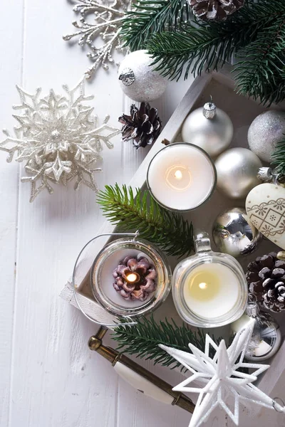Tarjeta navideña con pequeñas velas brillantes y conos de abeto —  Fotos de Stock