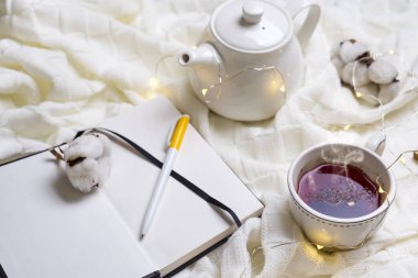 Sıcak örme şal, fincan sıcak çay ve defter