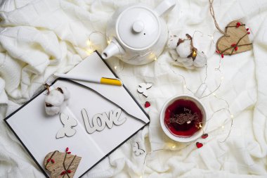 Sıcak örme şal, fincan sıcak çay ve defter
