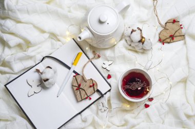 Sıcak örme şal, fincan sıcak çay ve defter