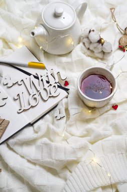 Sıcak örme şal, fincan sıcak çay ve defter