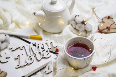 Sıcak örme şal, fincan sıcak çay ve defter