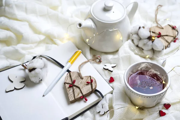 Sıcak örme şal, fincan sıcak çay ve defter