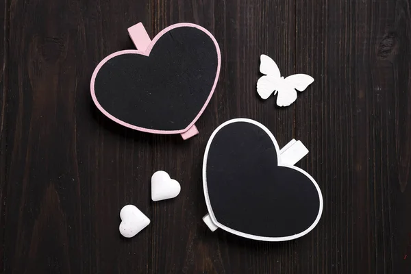 Two wooden hearts with butterfly on wooden background. — Stock Photo, Image