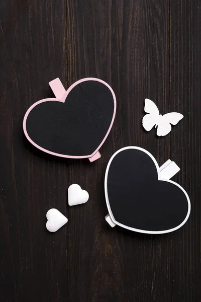 Dvě dřevěné srdce s motýlkem na dřevěné pozadí. — Stock fotografie