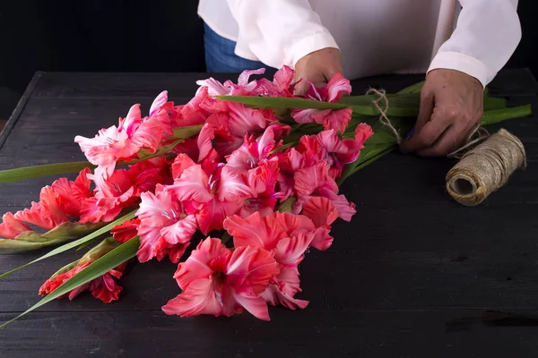 Les mains des femmes créent un bouquet de fleurs de gladiolus — Photo
