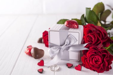 Taze kırmızı güller ve hediye kutusu ahşap tablo