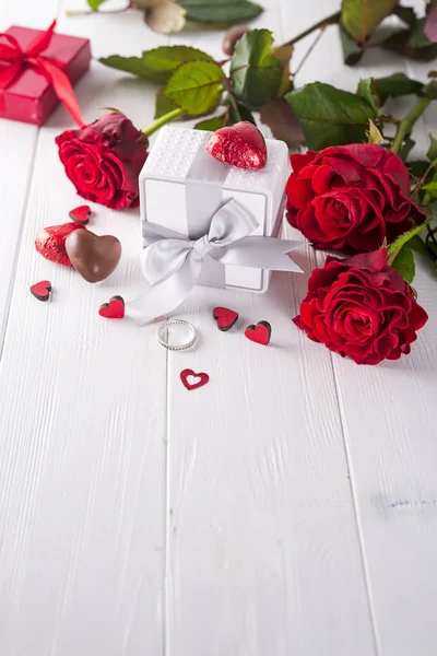 Roses rouges fraîches et coffret cadeau sur table en bois — Photo