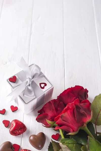 Roses rouges fraîches et coffret cadeau sur table en bois — Photo