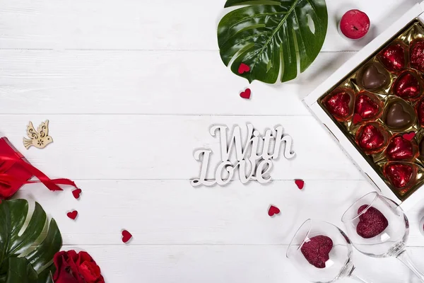 Deliziose caramelle al cioccolato in confezione regalo su sfondo di legno bianco — Foto Stock