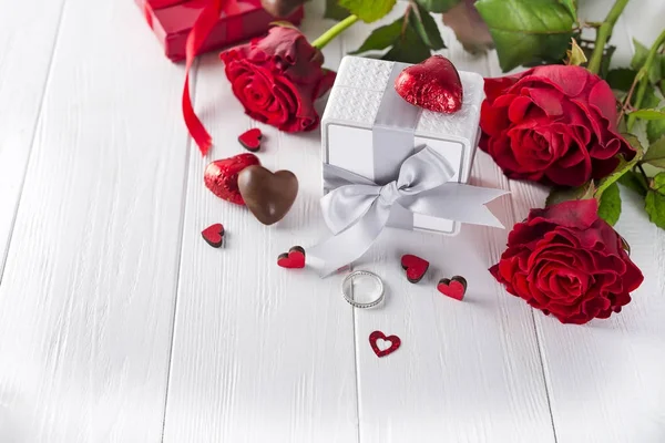 Roses rouges fraîches et coffret cadeau sur table en bois — Photo