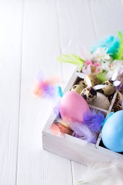 Beyaz ahşap kutusunda renkli Paskalya yumurtaları