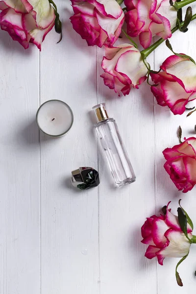Парфумерна пляшка, свічка і рожева троянда — стокове фото