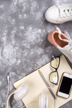 Yaz tatil kavramı: akıllı telefon, beyaz spor ayakkabı, not defteri, kulaklık, kalem