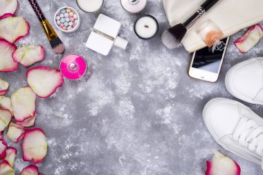 Kozmetik parfüm, telefon ve kopya alanı ile gri bir arka plan üzerinde ayakkabı ile gül buketi