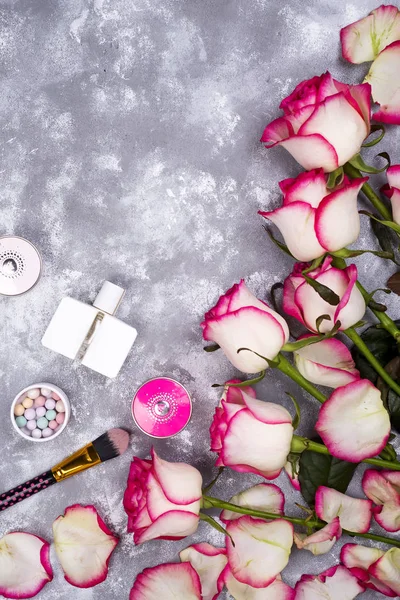 Ramo de rosas con cosméticos en perfume sobre un fondo gris con espacio para copiar —  Fotos de Stock