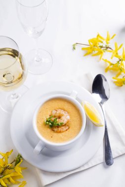 Deniz ürünleri ve beyaz zemin üzerine limon kremalı çorba.