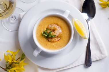 Deniz ürünleri ve beyaz zemin üzerine limon kremalı çorba.