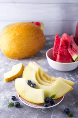 Olgun kavun açık bir taş renkli bir tabağa dilimlenmiş