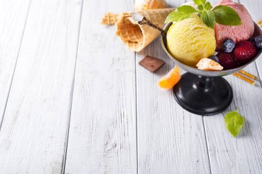 Beyaz, sarı, kırmızı renkleri ile üç farklı Kepçe dondurma ile kase ve koni, çikolatalı gözleme,