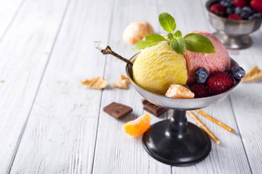 Sarı, kırmızı renkleri ile üç farklı Kepçe dondurma ile kase ve koni, çikolatalı gözleme,