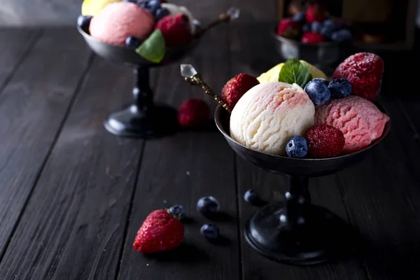 Cuenco con helado con tres cucharadas diferentes de colores blanco, amarillo y rojo , —  Fotos de Stock