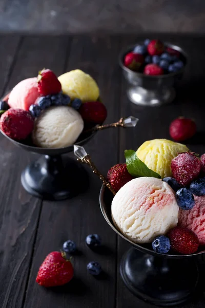 Cuenco con helado con tres cucharadas diferentes de colores blanco, amarillo y rojo , — Foto de Stock