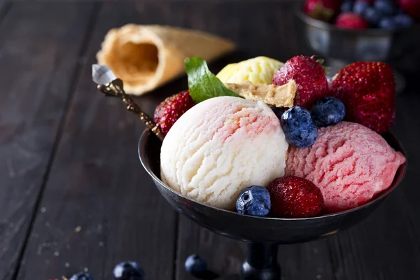 Чаша с мороженым с тремя различными шарами белого, желтого, красного цветов и вафельного конуса — стоковое фото