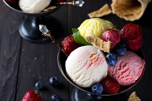 Cuenco con helado con tres cucharadas diferentes de blanco, amarillo, colores rojos y cono de gofre —  Fotos de Stock