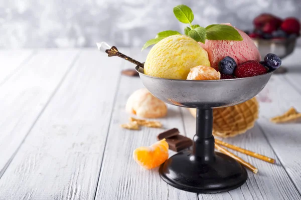 Cuenco con helado con tres cucharadas diferentes de color amarillo, rojo y cono de gofre, chocolate , — Foto de Stock