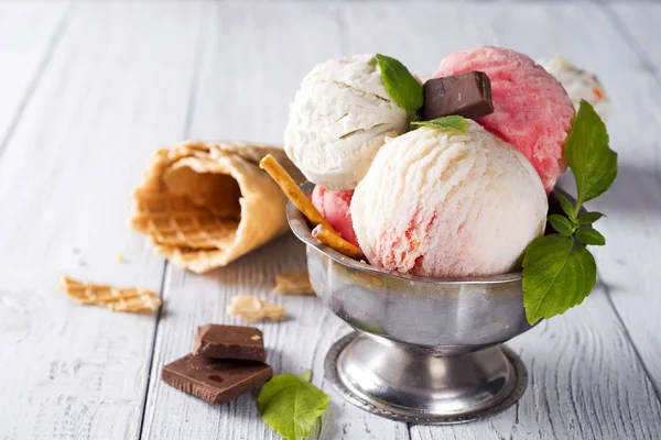 Helado de vainilla y rosa en un pial con bayas congeladas y cono de gofre — Foto de Stock